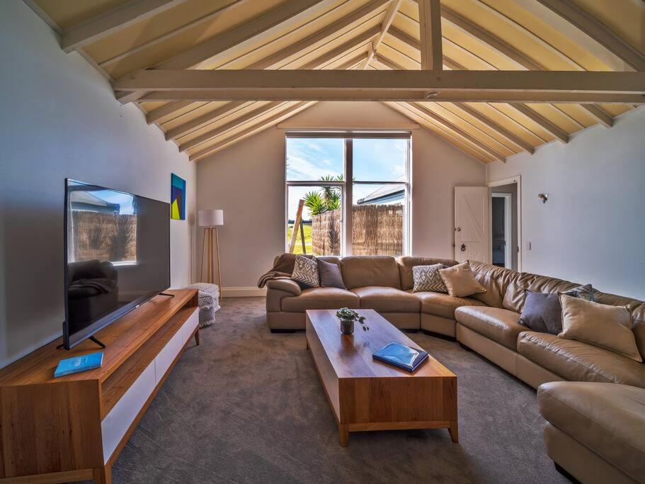 sala de estar con sofá y mesa en 3-bedroom home 4km to Grand Prix track, en Smiths Beach