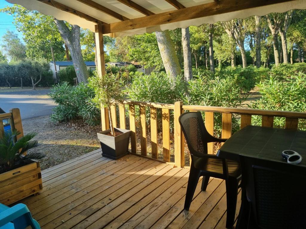 a wooden deck with a table and chairs on it at Mobile home De Luxe St Cyprien in Saint-Cyprien