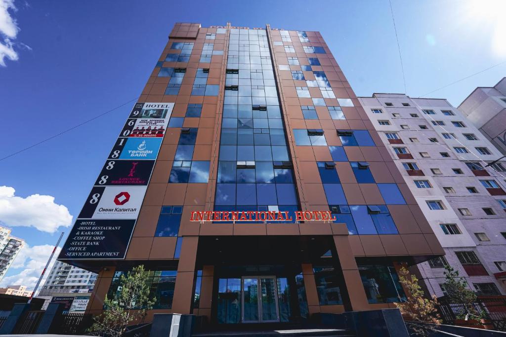 Un edificio alto con un cartel. en International Hotel in Ulaanbaatar, en Ulán Bator