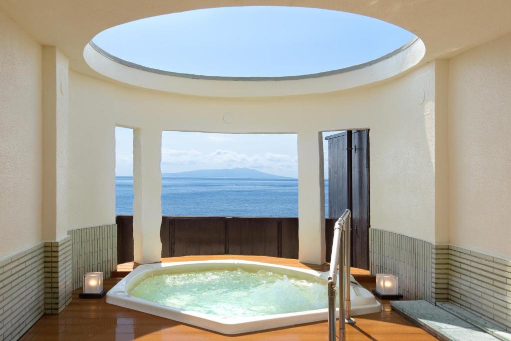 a large bath tub in a room with a window at Tsuruya Kisshotei in Higashiizu