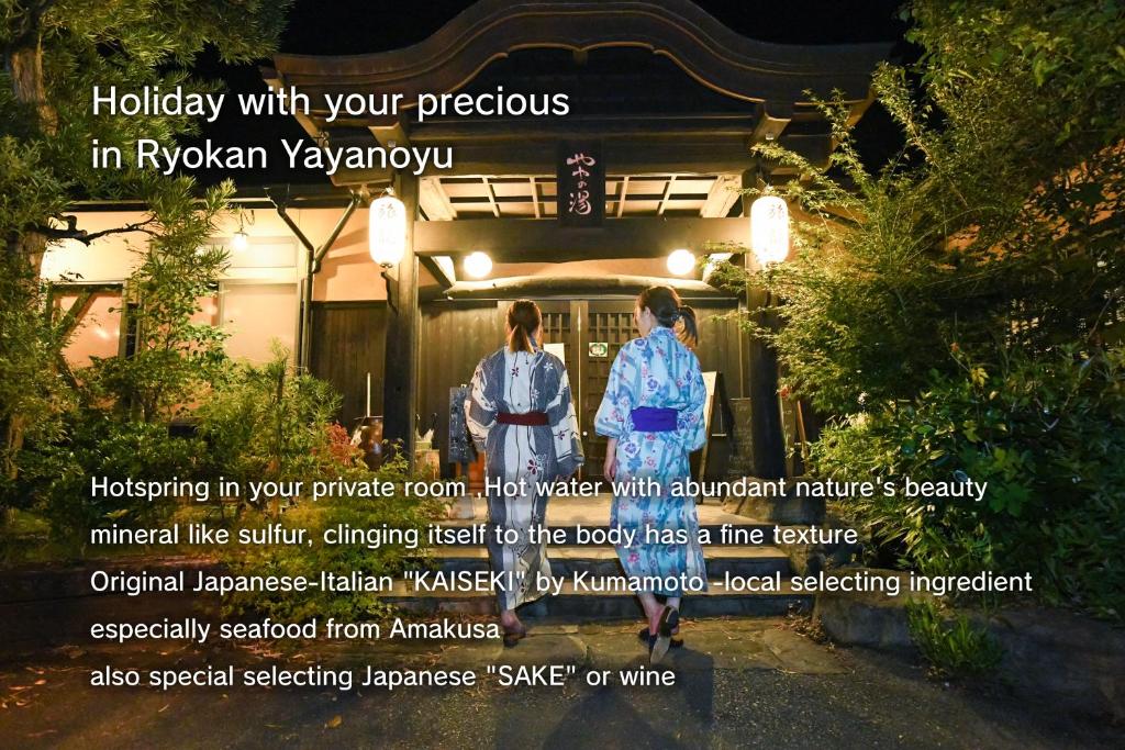 two people standing in front of a house at night at Ryokan Yayanoyu in Ueki