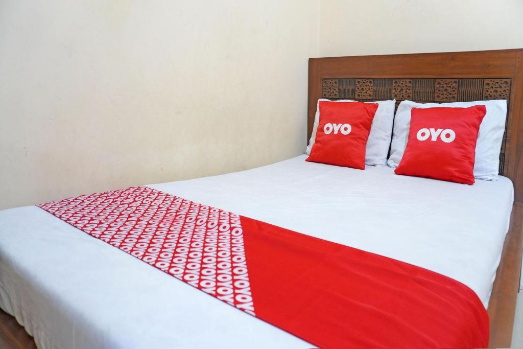 - un lit avec 2 oreillers rouges dans l'établissement OYO 91762 Green Home Stay Syariah, 