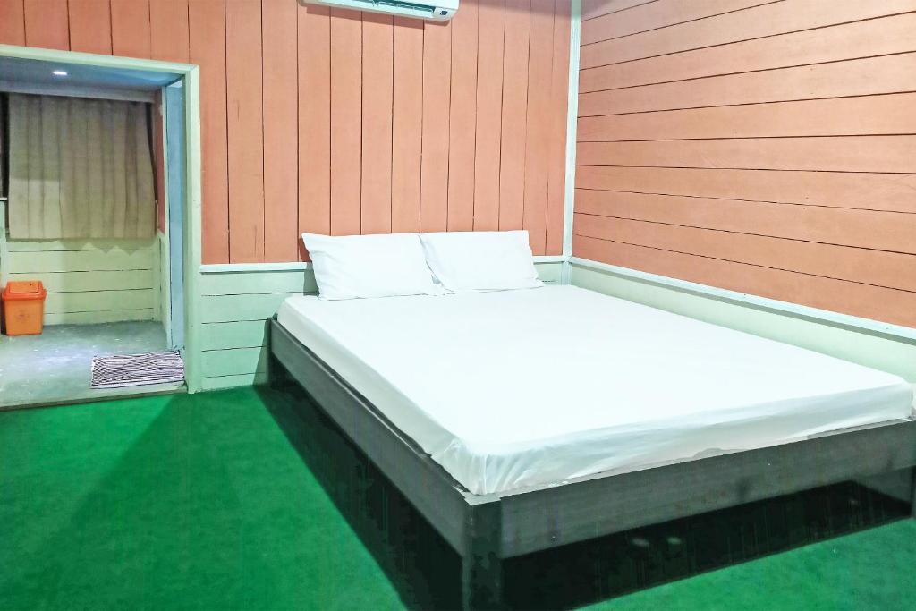 een bed in de hoek van een kamer bij OYO 91768 Hotel Tanjung Permai in Tanjungselor