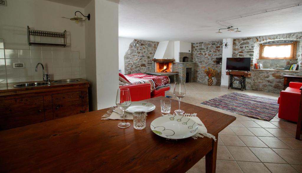 a kitchen and a living room with a wooden table at IL COMO' DELLA CIVETTA - Taverna “La Fenice” in Stazzona