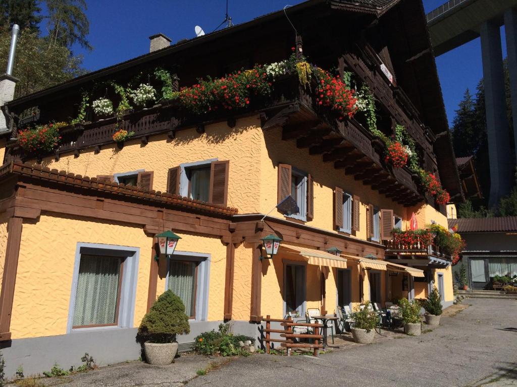 a building with potted plants on the side of it at Klammer Gasthof in Kremsbrücke