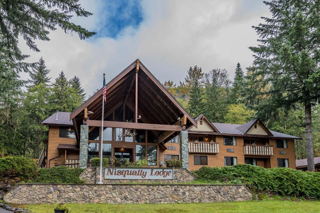 a large wooden house with a sign in front of it at Nisqually Lodge in Ashford
