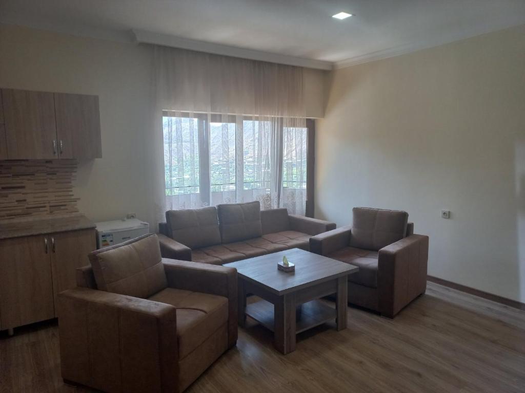 Meghri的住宿－Gam guest house 1，客厅配有沙发、两把椅子和一张桌子