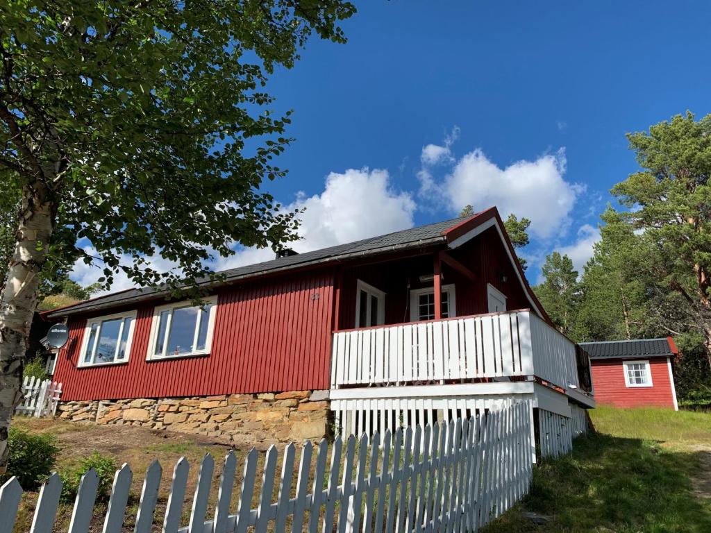 a red house with a white fence in front of it at Rondablikk in Folldal