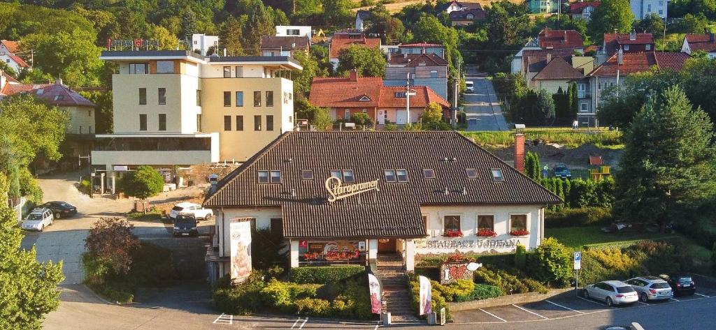 a house with a brown roof in a city at Penzion a Restaurace U Johana in Zlín