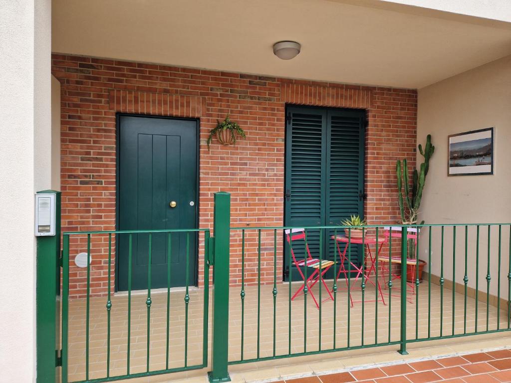 un balcón con una puerta verde y una silla en La casina sul lago, en Arezzo