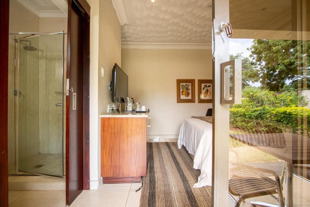 um quarto com uma cama e uma porta de vidro deslizante em The Victoria Falls Deluxe Suites em Victoria Falls