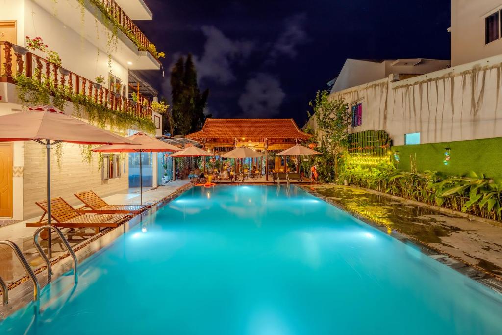a swimming pool in a hotel at night at Alley Garden Homestay Hoi An in Hoi An