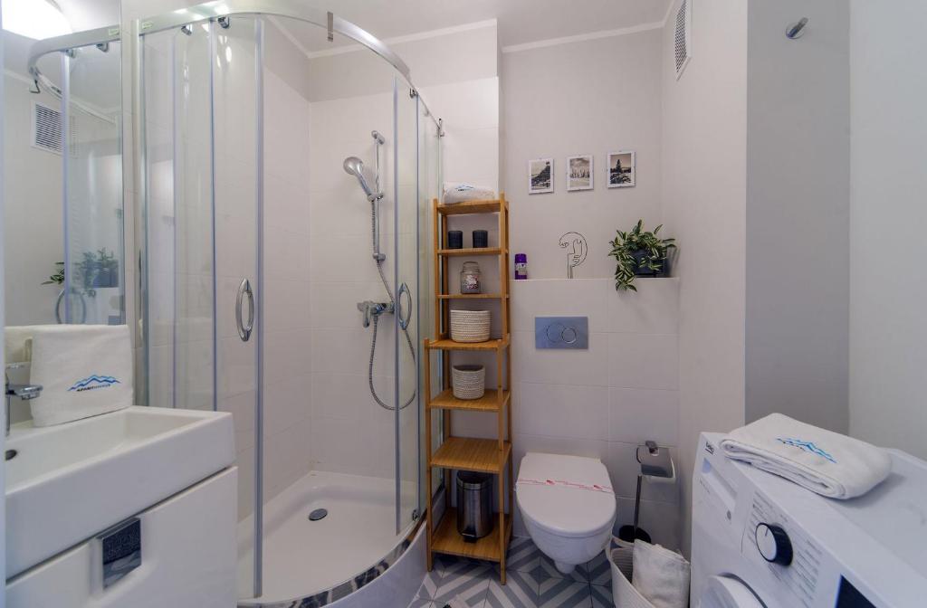 een badkamer met een douche, een toilet en een wastafel bij Apart Invest Perła D6 in Szklarska Poręba