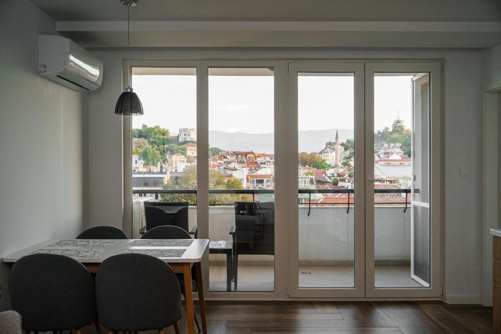 a dining room with sliding glass doors with a view at South Panoramic Apartment in the art district of Kapana in Plovdiv