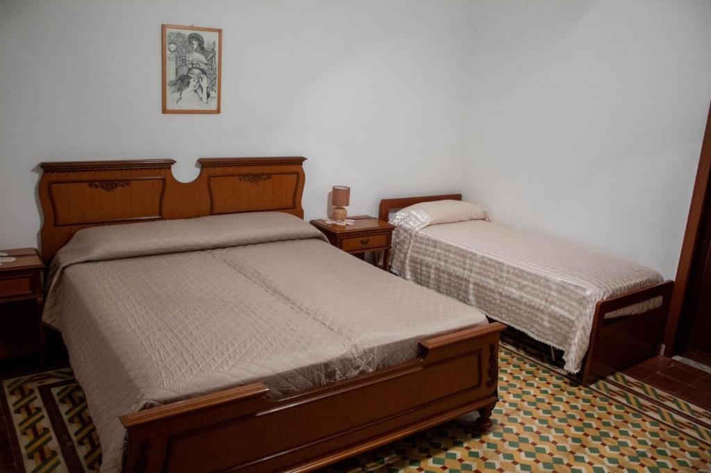 トラーパニにあるAppartamento Erice Bassaのベッドルーム1室(ベッド2台、ナイトスタンド2台付)