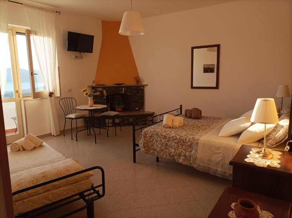 Habitación de hotel con 2 camas, mesa y sillas en FarmaMia, en Ascea