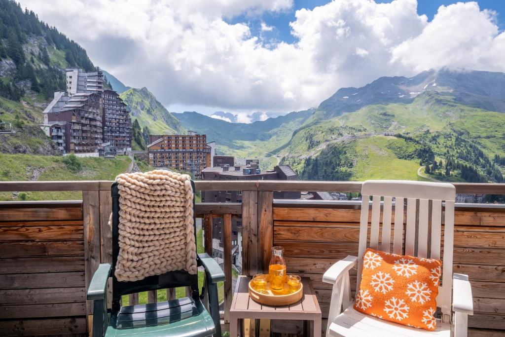 a balcony with two chairs and a view of mountains at Résidence Pierre &amp; Vacances Electra in Avoriaz