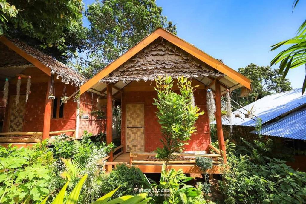 une petite maison rouge avec un toit dans l'établissement ลุงนะ โฮมสเตย์ ปางอุ๋ง แม่ฮ่องสอน, à Ban Huai Makhuea Som