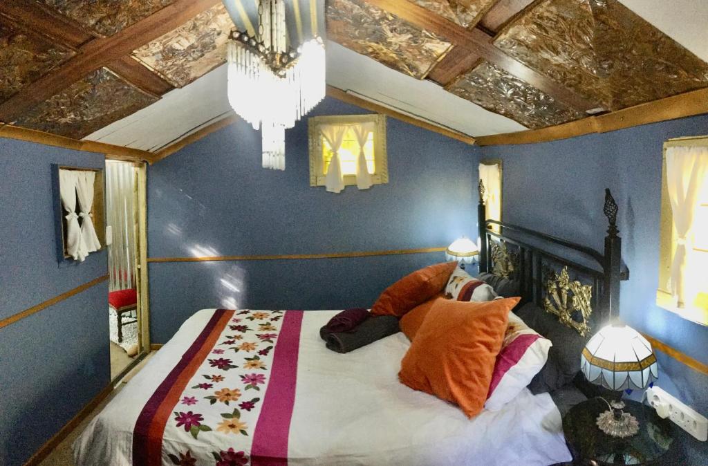 a bedroom with a bed with blue walls and a chandelier at The shack life in Rensburgdorp