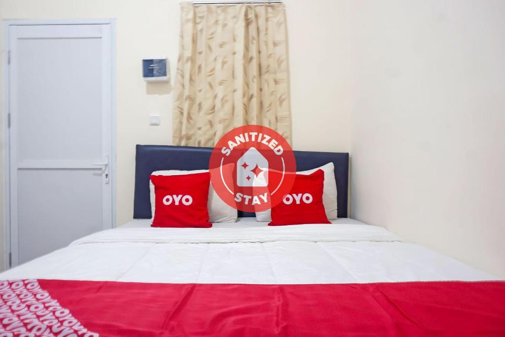a red and white bed with red pillows on it at SUPER OYO Capital O 91790 S1 Residence in Tangerang