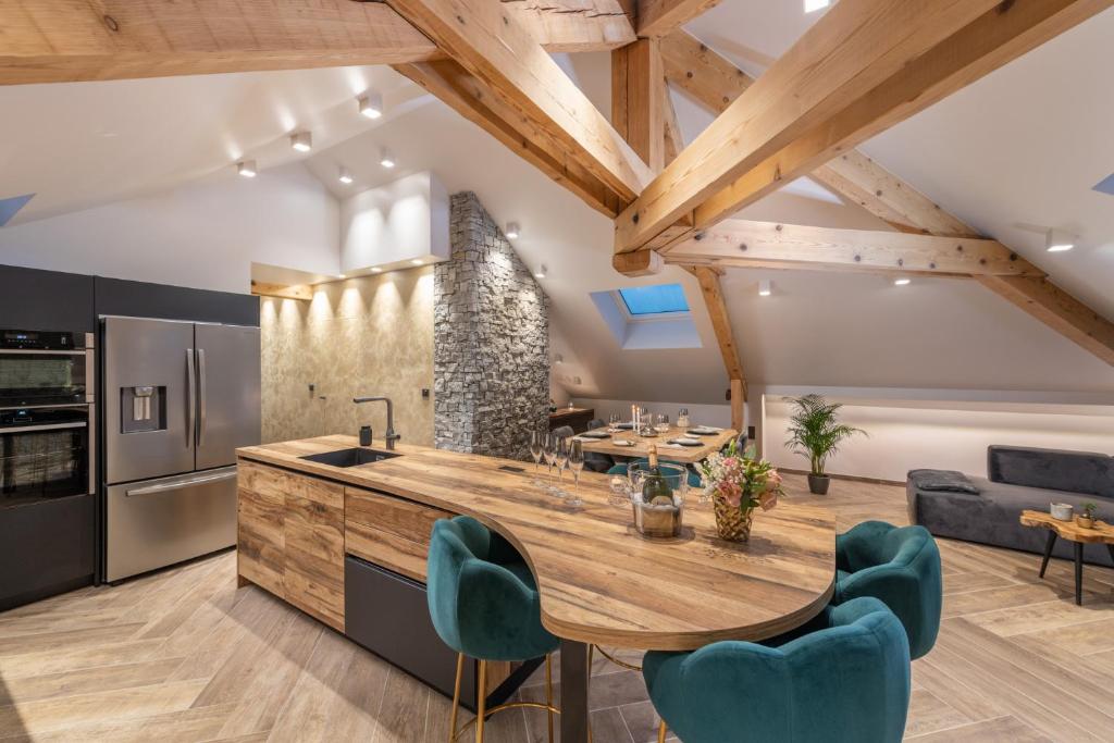 eine Küche mit einem Holztisch und blauen Stühlen in der Unterkunft Mairnaige, luxueux appartement avec sauna in Gérardmer