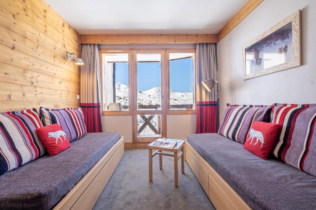 a living room with two couches and a window at Résidence Pierre &amp; Vacances Les Néréides in Belle Plagne