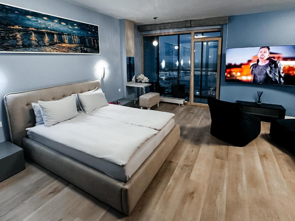 a bedroom with a bed and a flat screen tv at sky DREAM jacuzzi sauna 33 FLOOR in Klaipėda