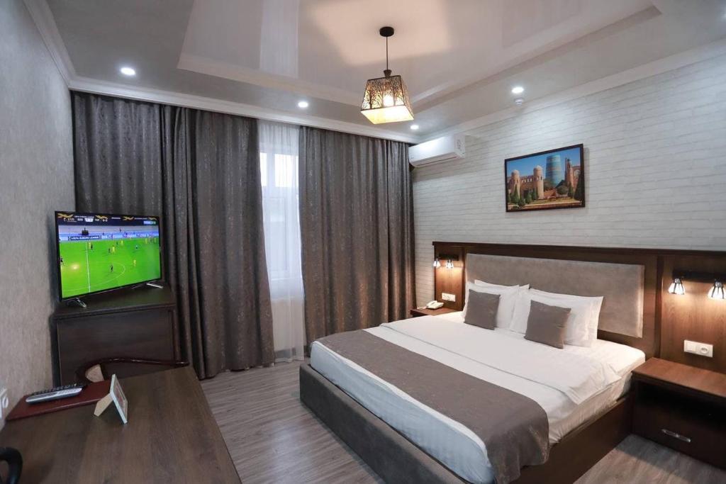 a hotel room with a bed and a television at Hotel Byond Tashkent in Tashkent