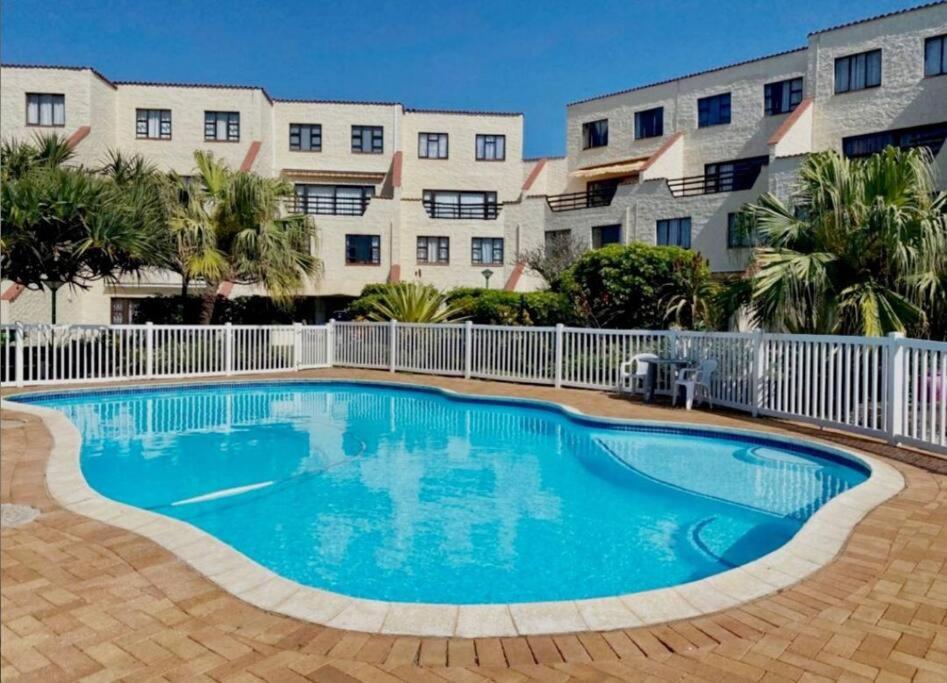a swimming pool in front of a building at La Corsica Beach House Breakaway in Margate