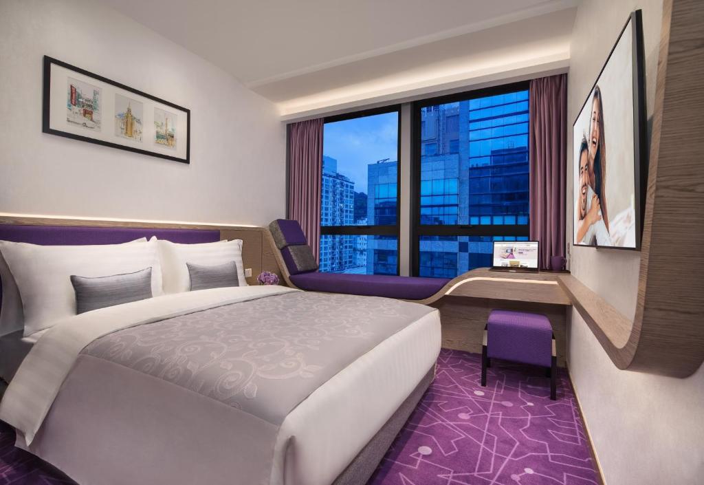 ein Schlafzimmer mit einem großen Bett und einem großen Fenster in der Unterkunft Hotel Purple Hong Kong in Hongkong