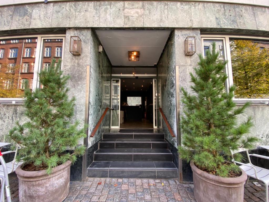 two trees in pots in front of a building at Hotel Maritime in Copenhagen