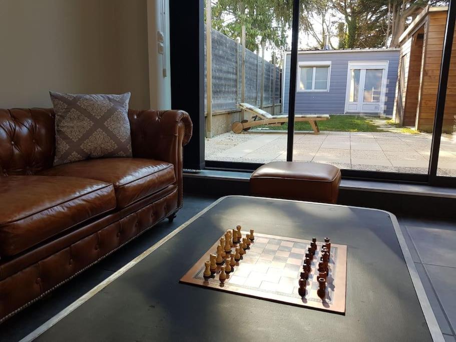 Habitación con sofá y tablero de ajedrez sobre una mesa. en spacieuse maison de ville avec espace détente en Rezé