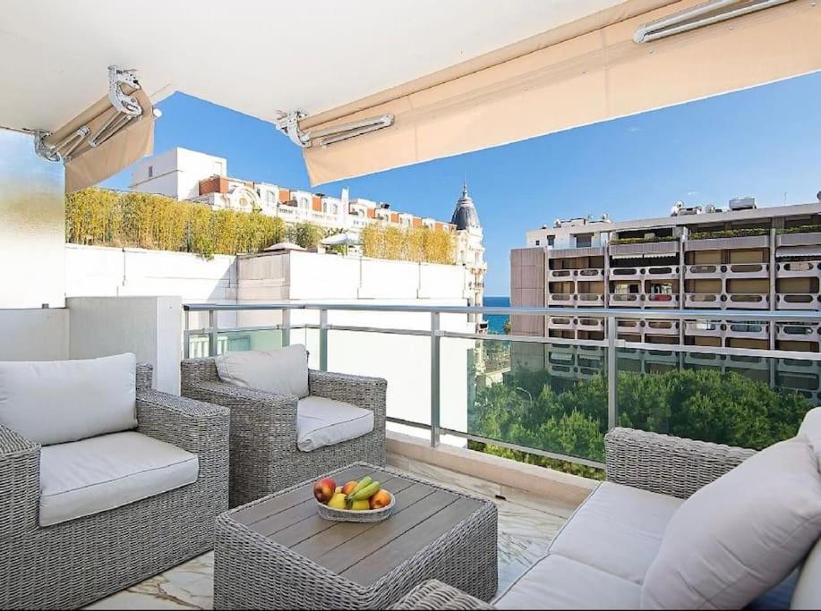 - un balcon avec des chaises et une corbeille de fruits sur une table dans l'établissement Le Lucior - FLBK conciergerie, à Cannes