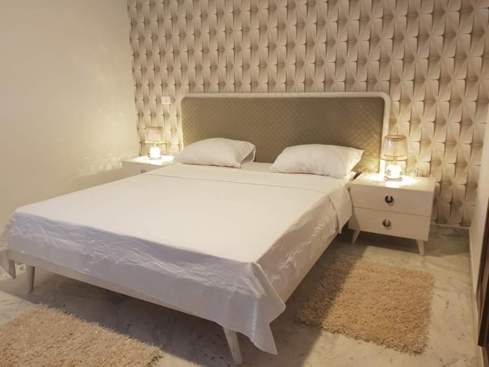 - une chambre avec un grand lit blanc et 2 tables de chevet dans l'établissement DreamStay And Wonderful Near Tunisia Mall Lac 2, à Tunis