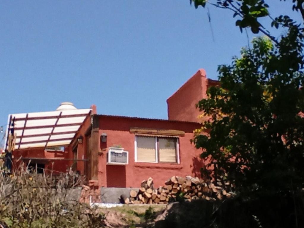 una casa roja con ventana y techo en Aguaribay cabañas en San Javier