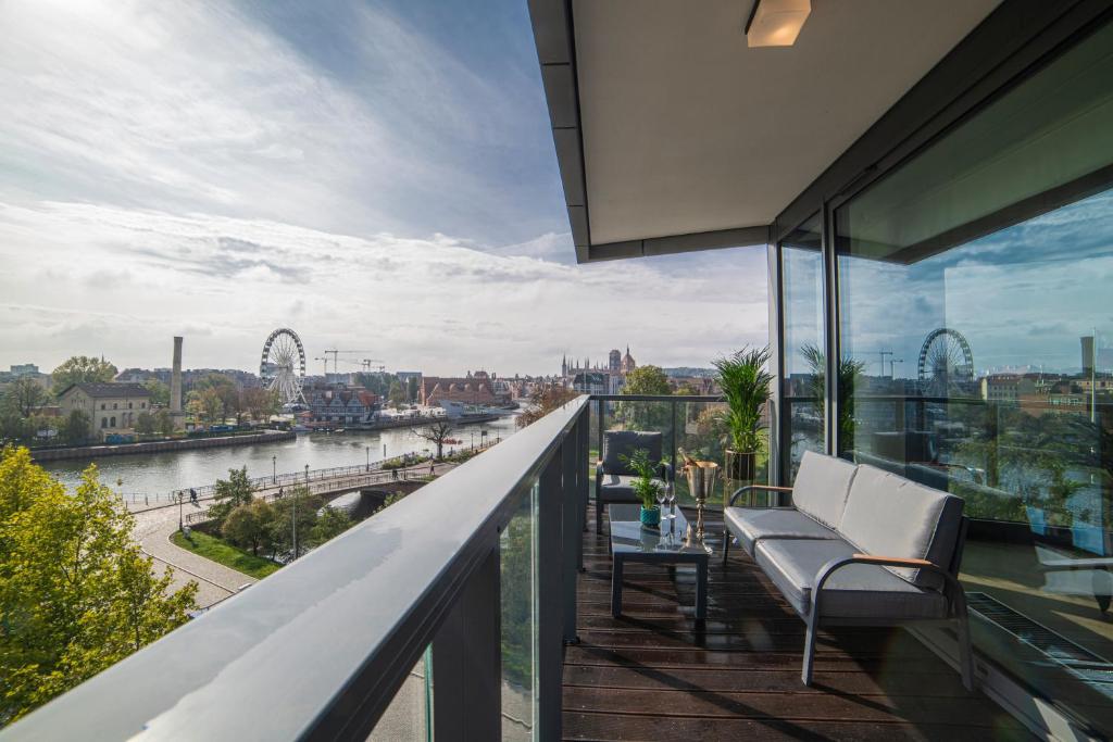 a balcony with two chairs and a view of the river at Apartament Amber Centrum Lux in Gdańsk
