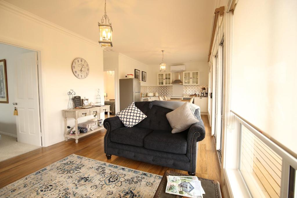 sala de estar con sofá y cocina en Bridgecroft Villa - French Provincial in Richmond with spa, en Richmond