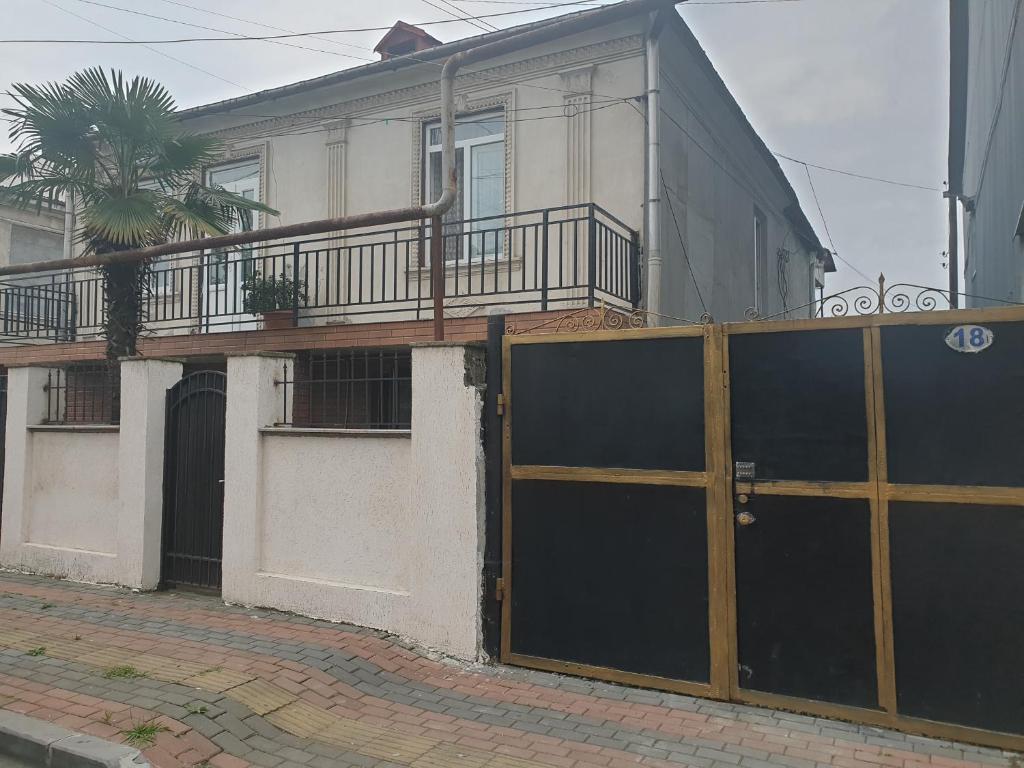 a house with a gate and a palm tree at Apartment on Lado Asatiani in Batumi