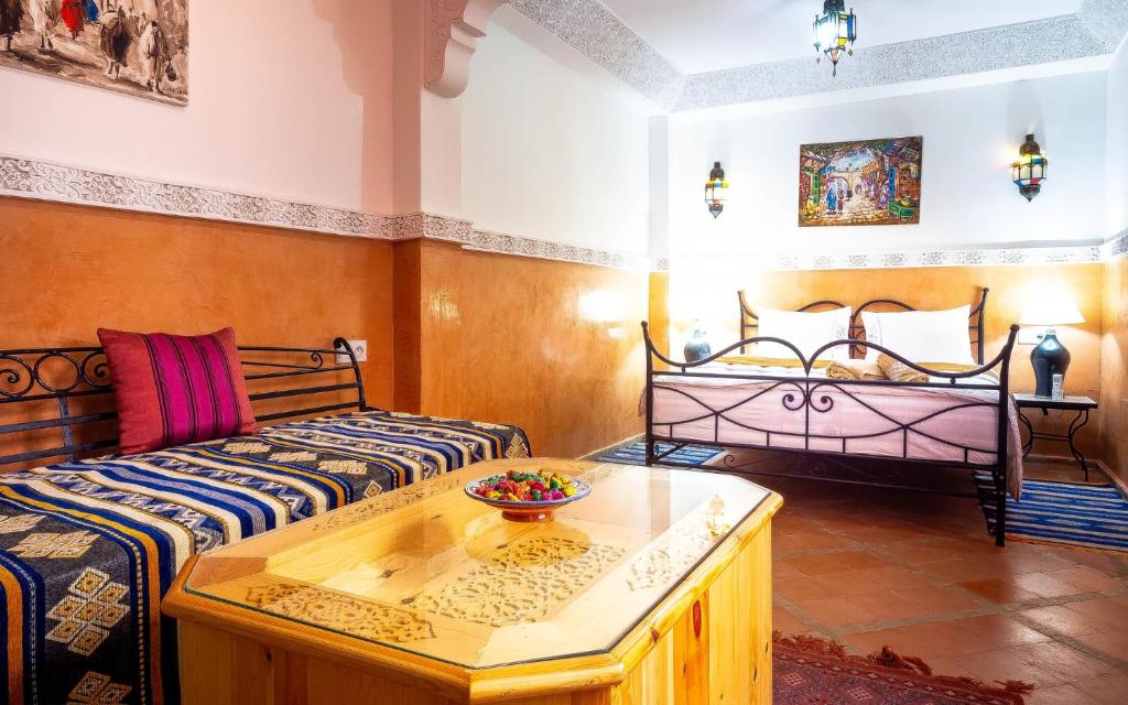 a living room with two beds and a table at RIAD BIEN ICI in Marrakesh