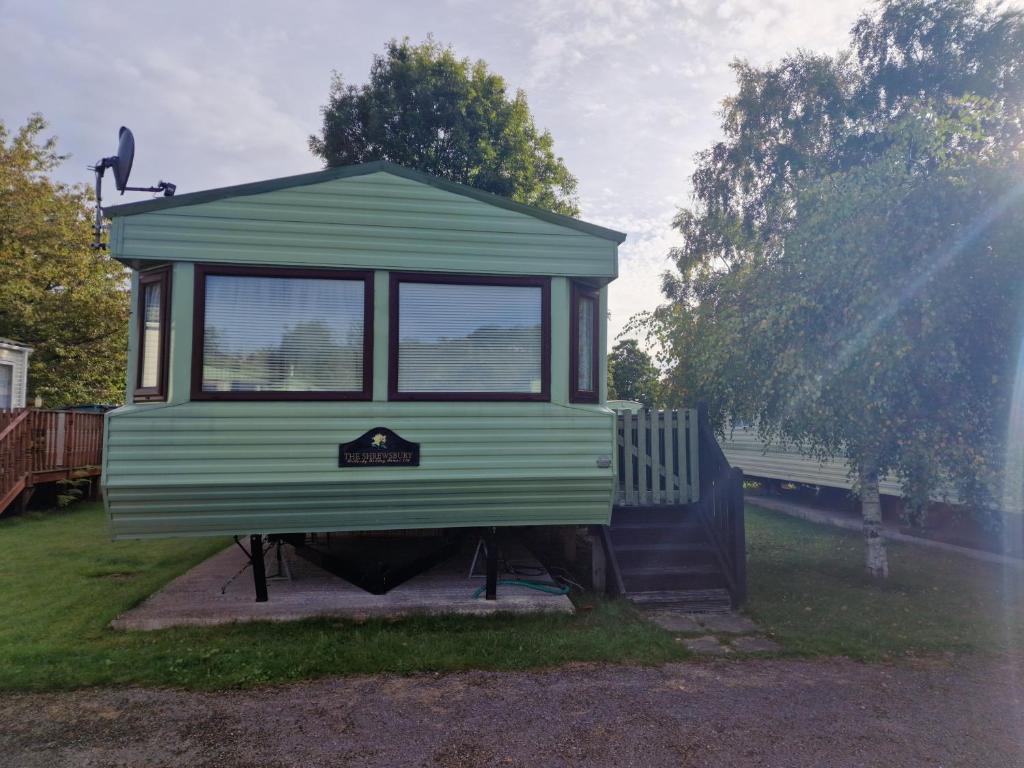 a tiny house on a stand in the grass at Willerby Shrewsbury - Pitch 51 in Welshpool