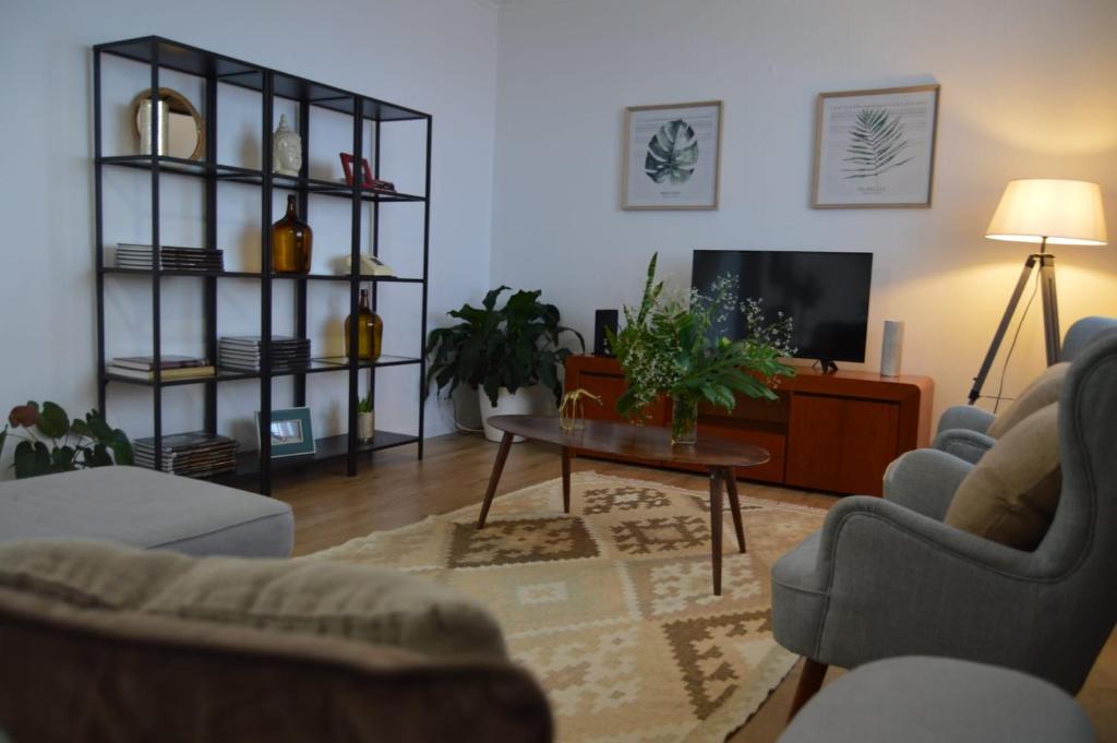 ein Wohnzimmer mit einem Sofa und einem Tisch in der Unterkunft Villa Reis Sao Goncalo in Funchal