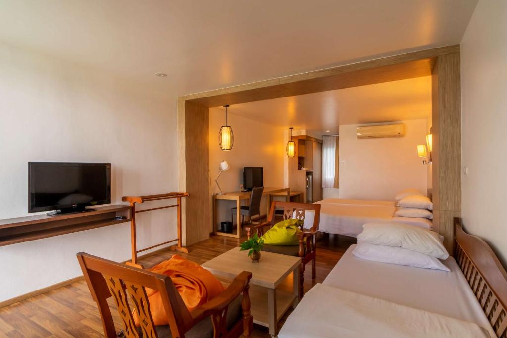 een hotelkamer met 2 bedden en een televisie bij Best Western Phuket Ocean Resort in Karon Beach