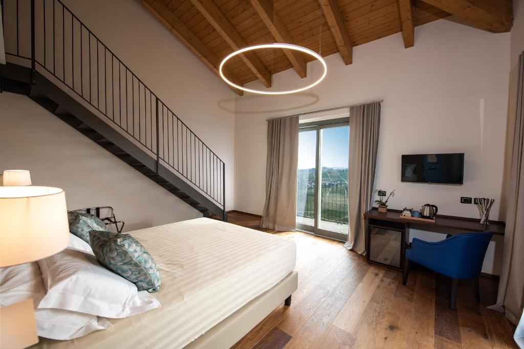 1 dormitorio con cama, escritorio y escalera en Bric D'Alù - Barbaresco, en Barbaresco