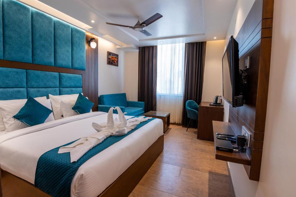 a hotel room with a bed and a flat screen tv at HOTEL VIVAAN REGENCY in Haridwār