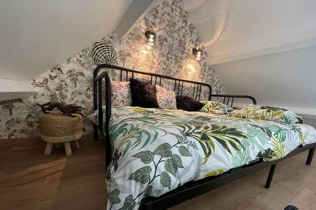 1 dormitorio con 1 cama con pared con motivos florales en Happy casita Disneyland Paris, en Chalifert
