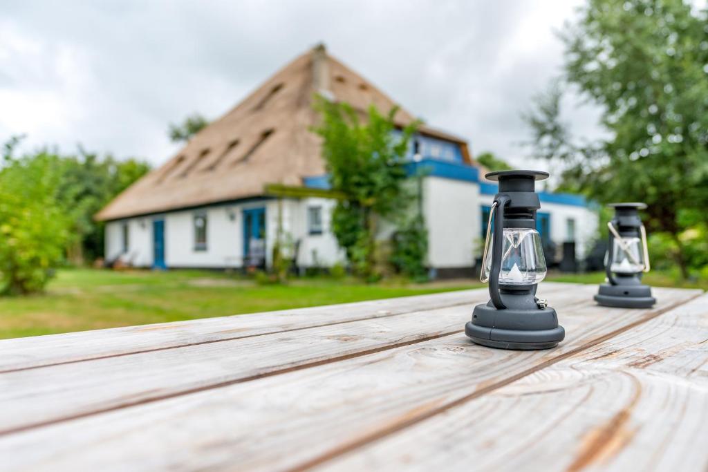 a pair of binoculars on a wooden table in front of a house at B&B De Oude Skuur in Oosterend