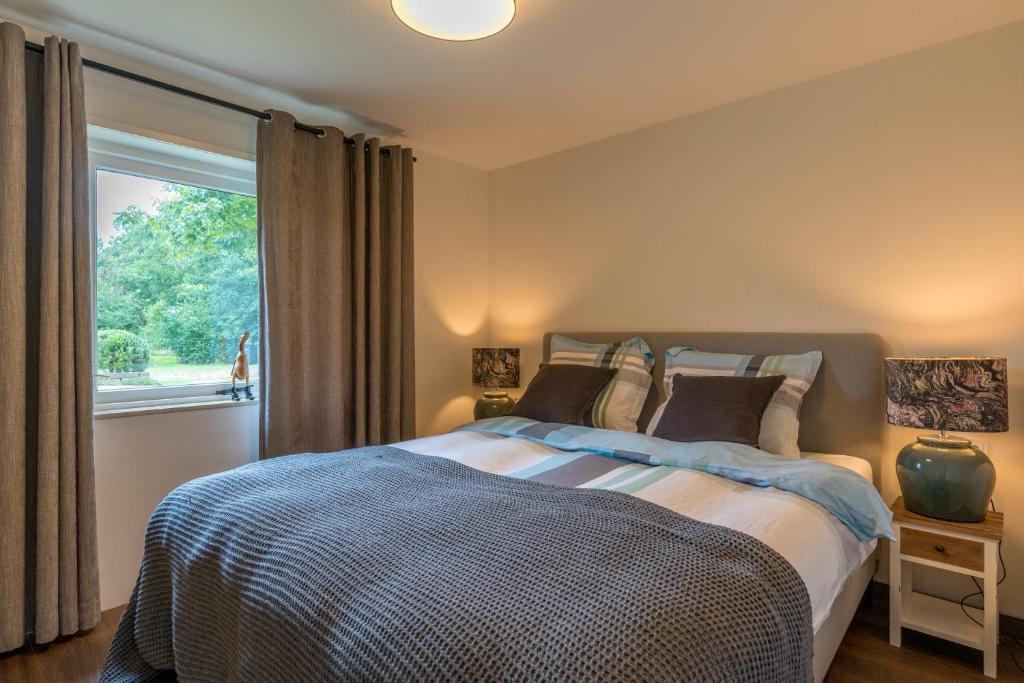een slaapkamer met een bed en een groot raam bij B&B De Oude Skuur Texel in Oosterend
