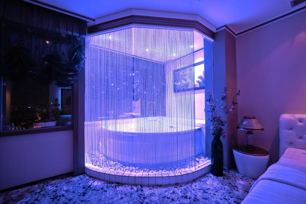 a large window with a tub in a room at Hotel Rosa Blu in Tirana