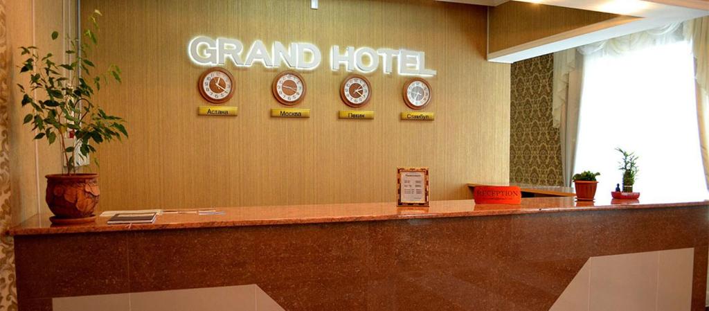 a grand hotel sign on the wall of a lobby at The Grand Hotel in Semey
