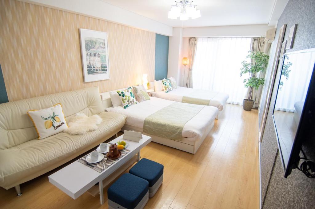 een woonkamer met een bank en een bed bij Nippombashi Art Hotel 705 in Osaka
